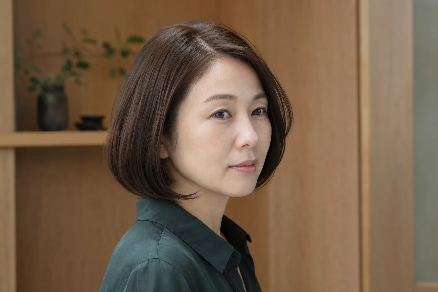 丸みのあるあご下ボブと斜め分けを右三四分から見せる成人女性