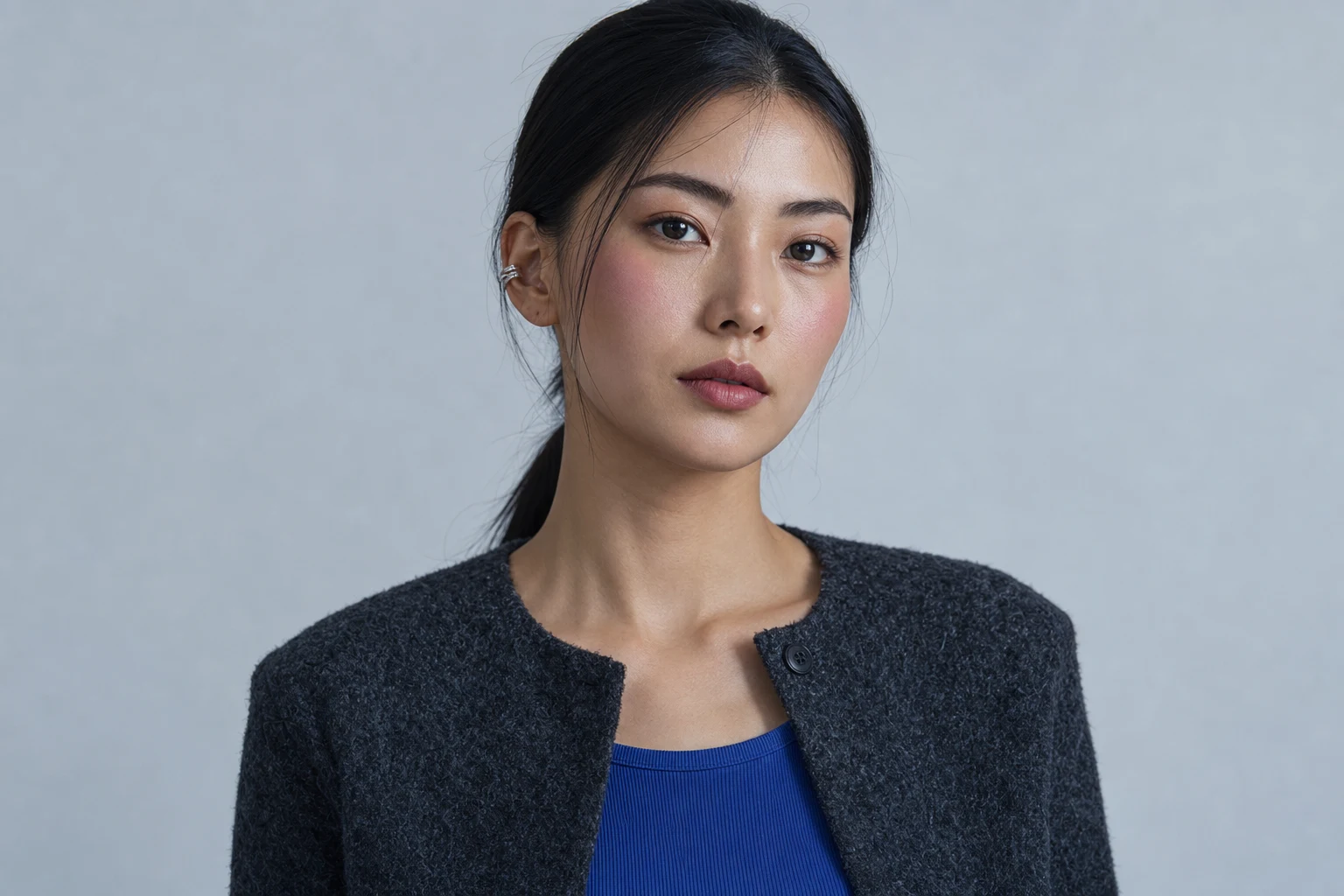 青みローズのチークを頬の高い中央へ薄くぼかした成人女性