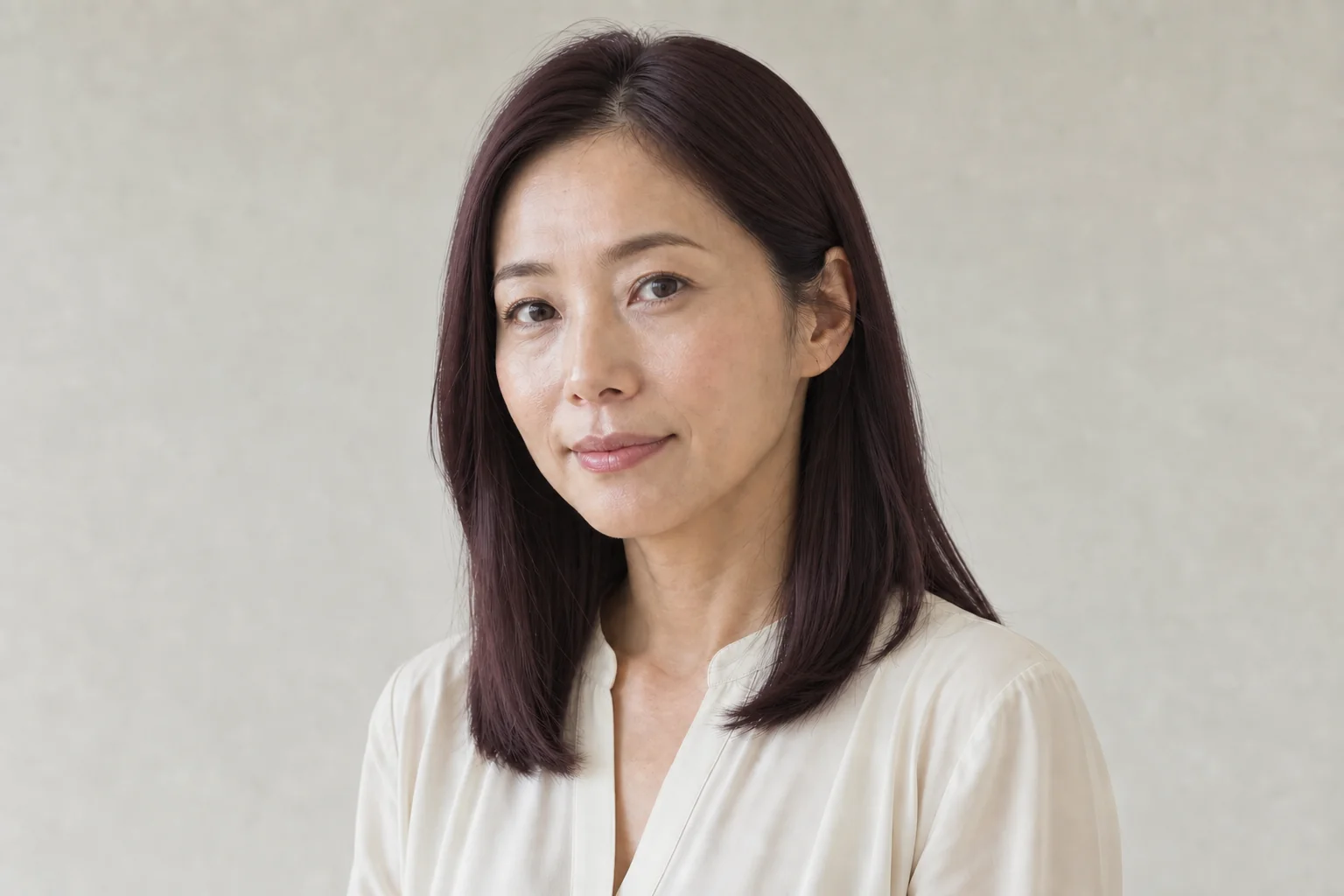 自然な中〜深めの肌色の成人女性と深いカシスプラムブラウンの肩下ロブ