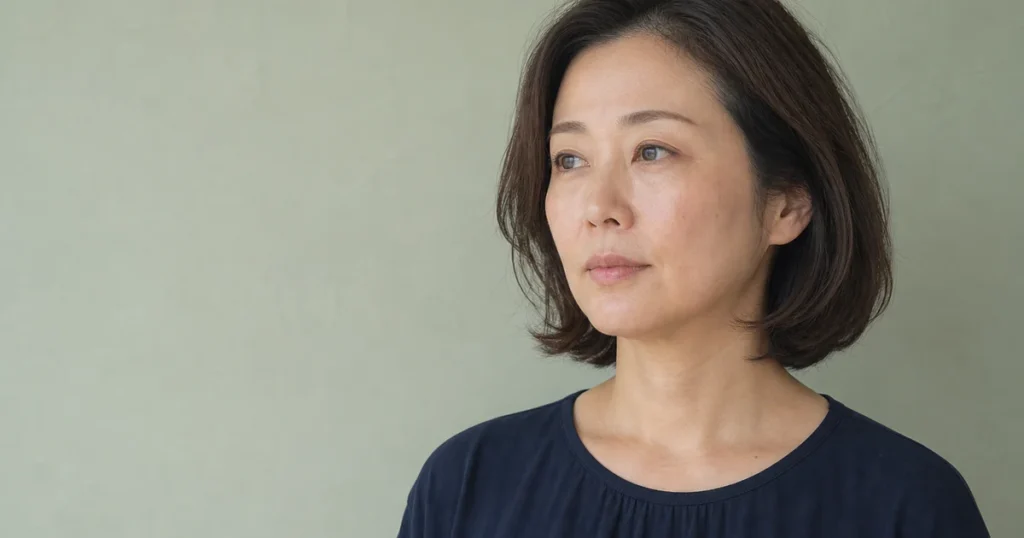 肩上の前髪なしボブを左前方から自然光で見せる成人女性