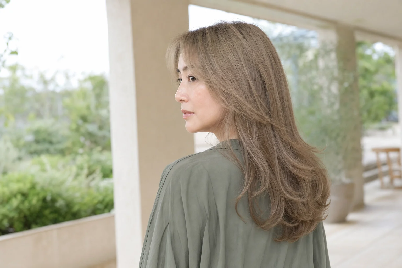 明るいベージュを残し灰みが見える胸上レイヤーヘアの成人女性