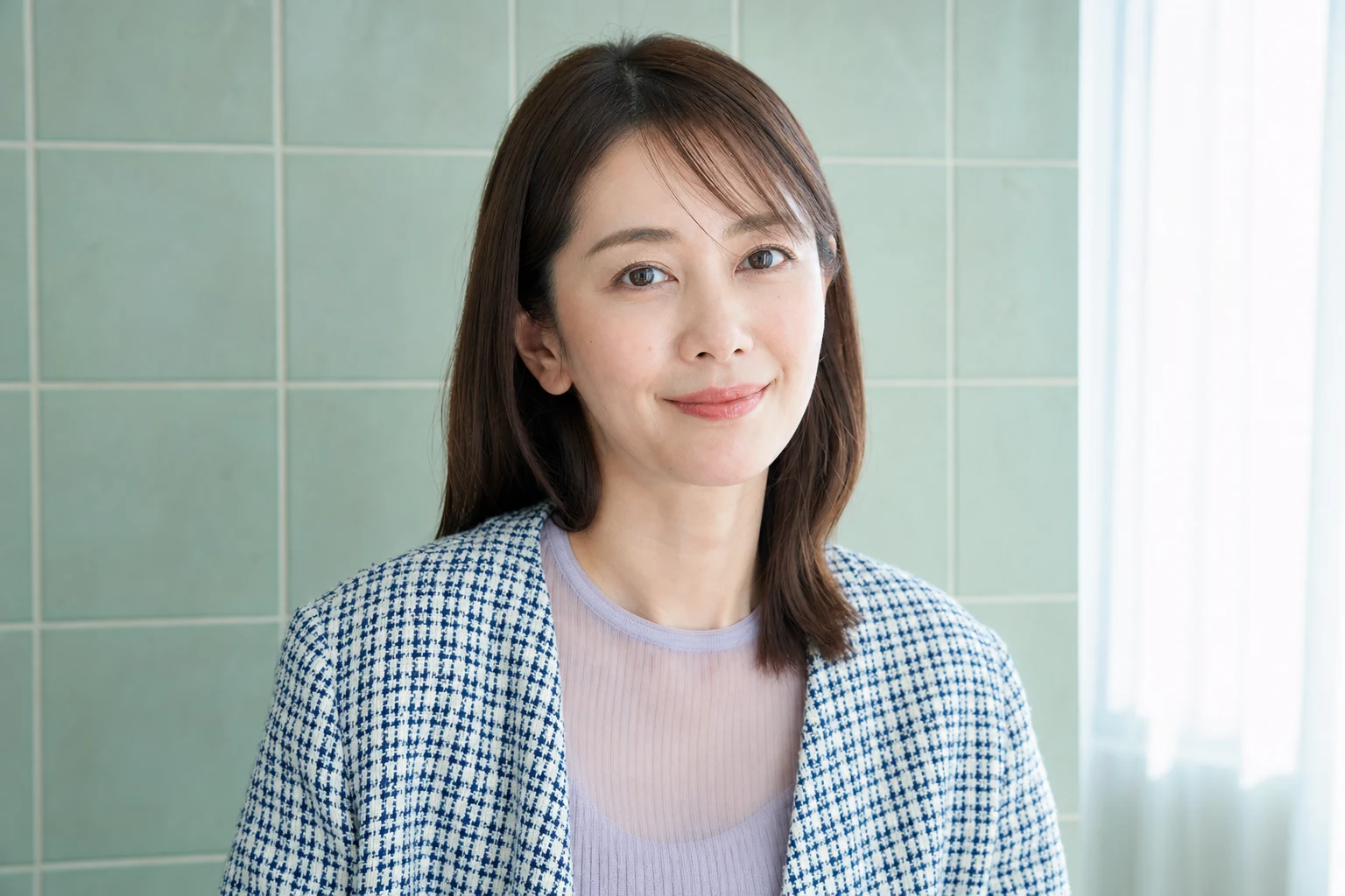 目の下へ透明パウダーを少量重ねた自然なセミマット肌の成人女性