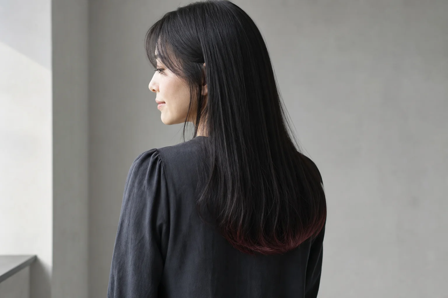 黒髪ロングの毛先だけに細い帯状のカシスブラウンを入れた裾カラー
