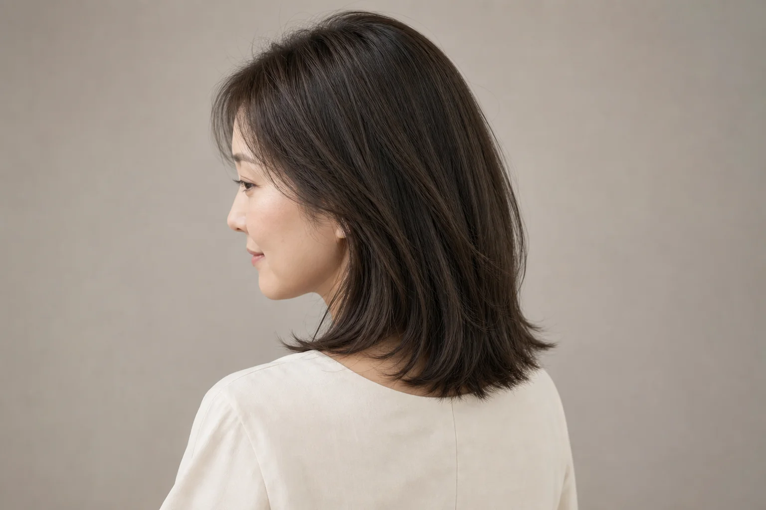 赤みを抑えたオリーブニュアンスの暗いグレージュの肩丈ロブ