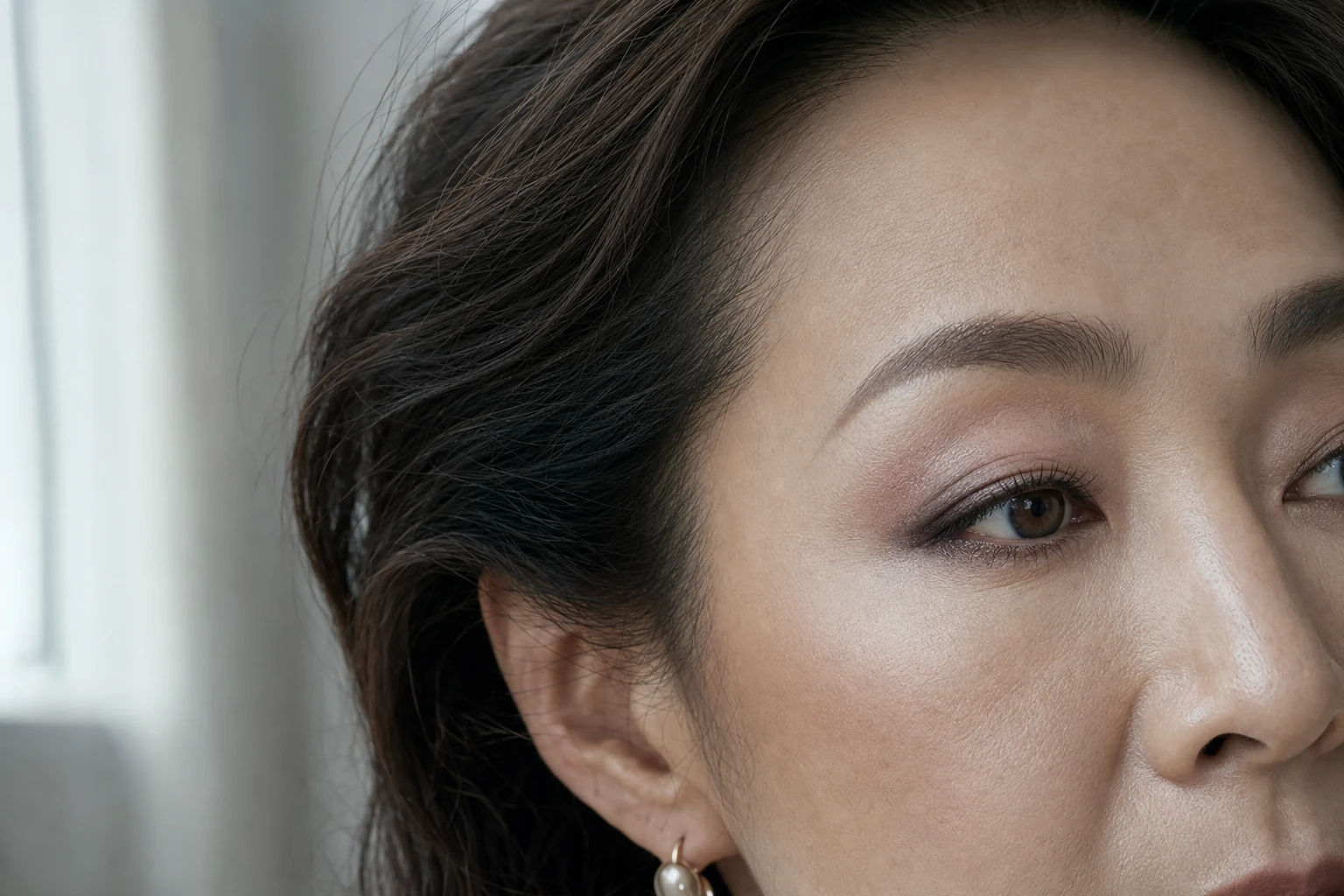 右目にモーヴベージュから深いプラムブラウンを重ねた成人女性の横顔寄り