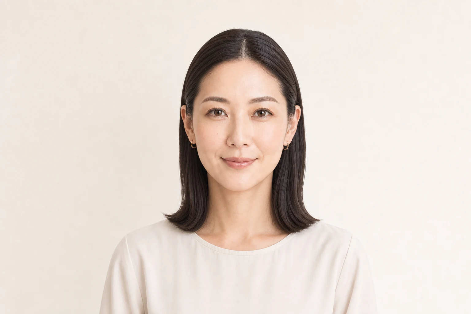 根元の高さを抑えて耳にかけた暗髪ロブのタイトなセンター分け