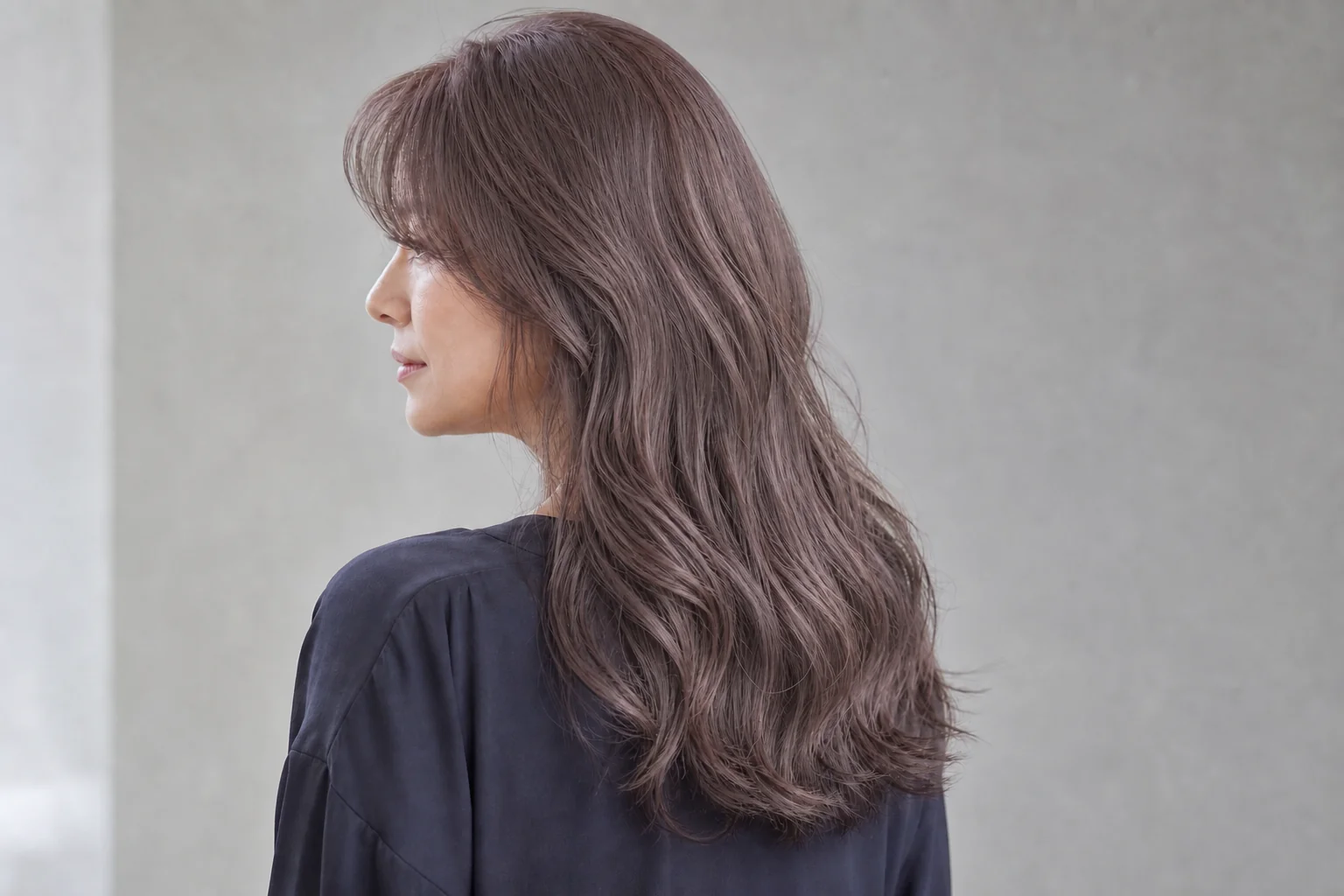 やわらかなソフトバイオレットベージュのロングヘアの成人女性