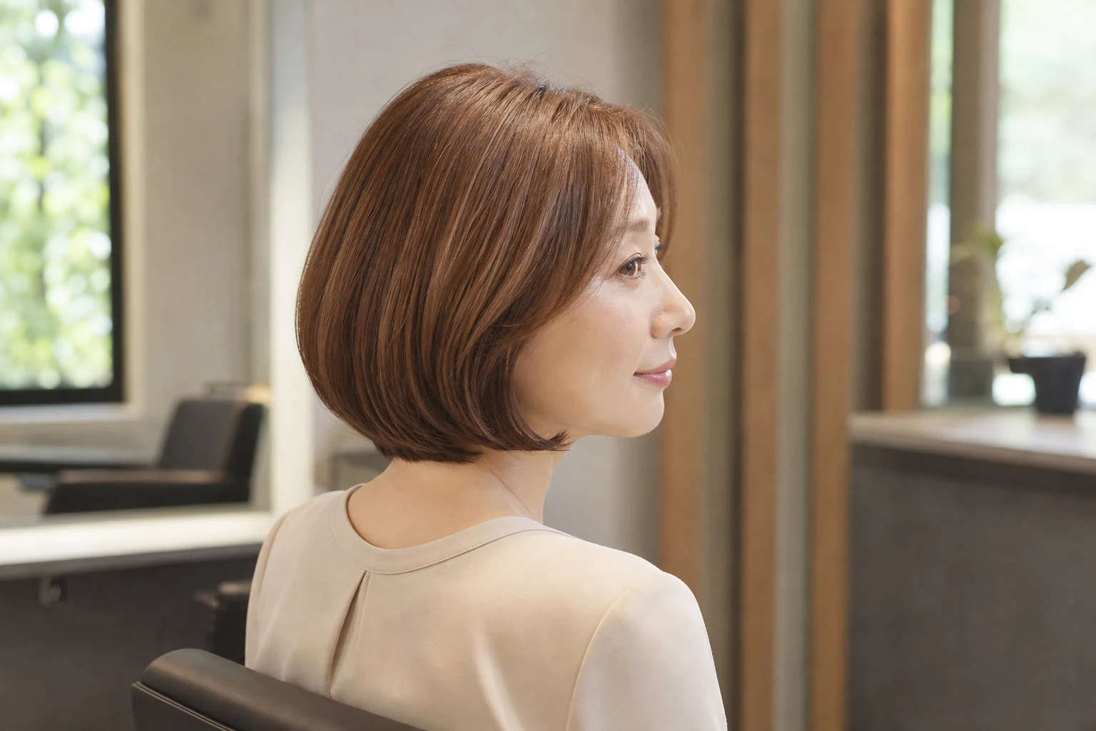 深めのストロベリーブロンドのボブヘアをまとった成人女性