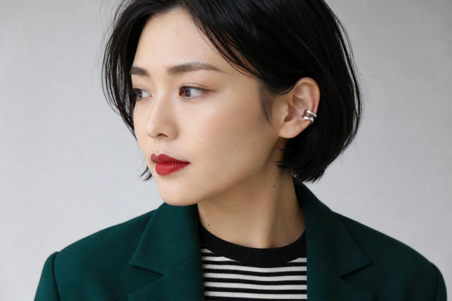 鮮やかなニュートラルレッドの唇と薄いトープの自然な眉を合わせた成人女性