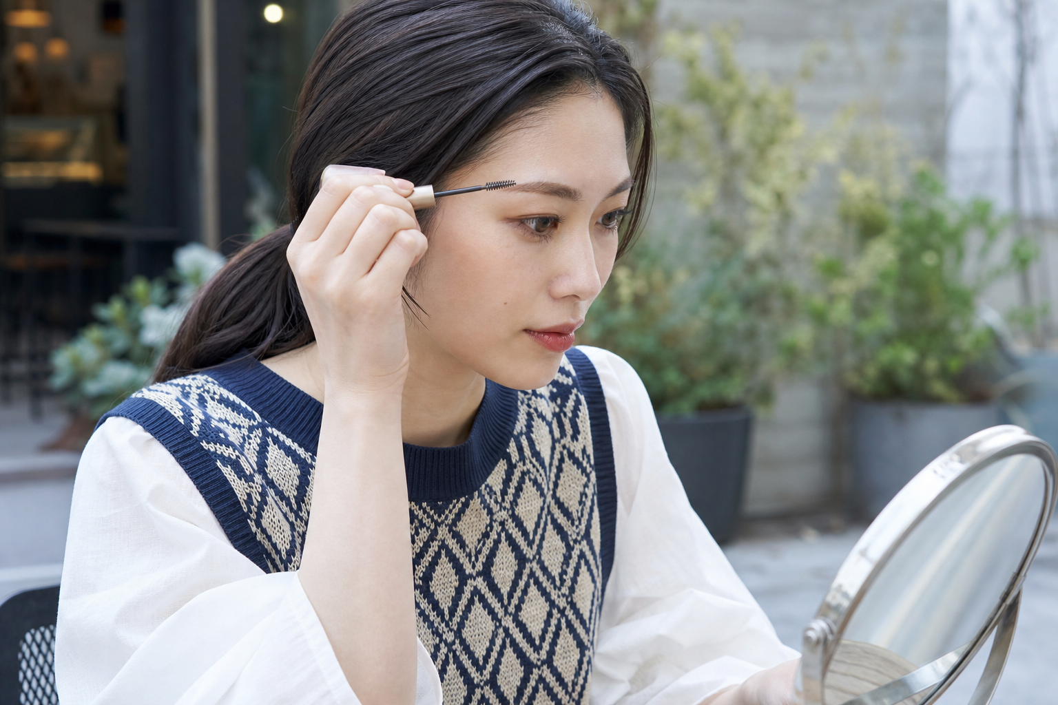 清潔なスクリューブラシで眉頭の毛流れを整える女性