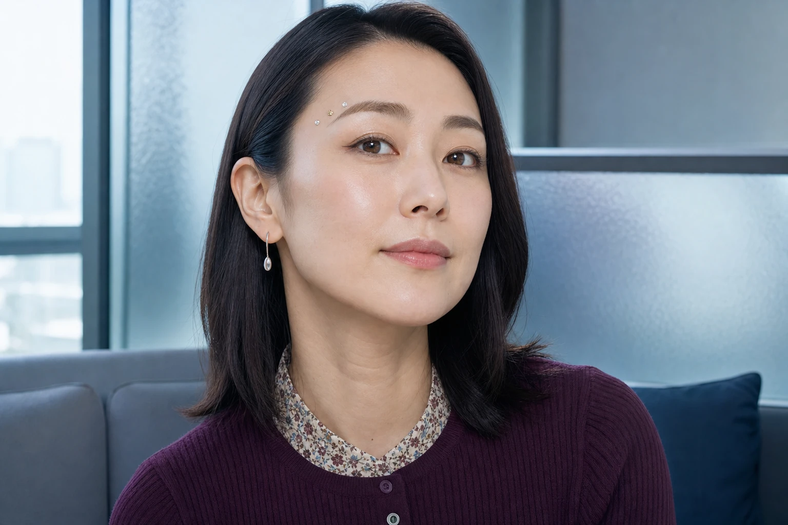眉尻の上に小さな透明と淡いシャンパン色のラインストーンを三粒置いた30代の成人女性