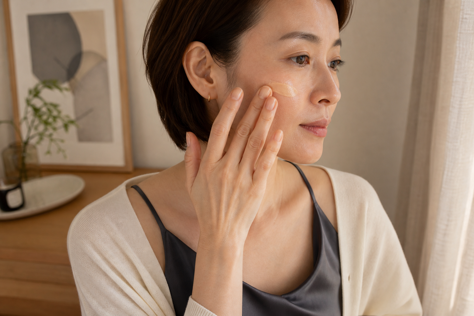 頬の中心から外側へBBクリームを薄く伸ばす女性の横顔