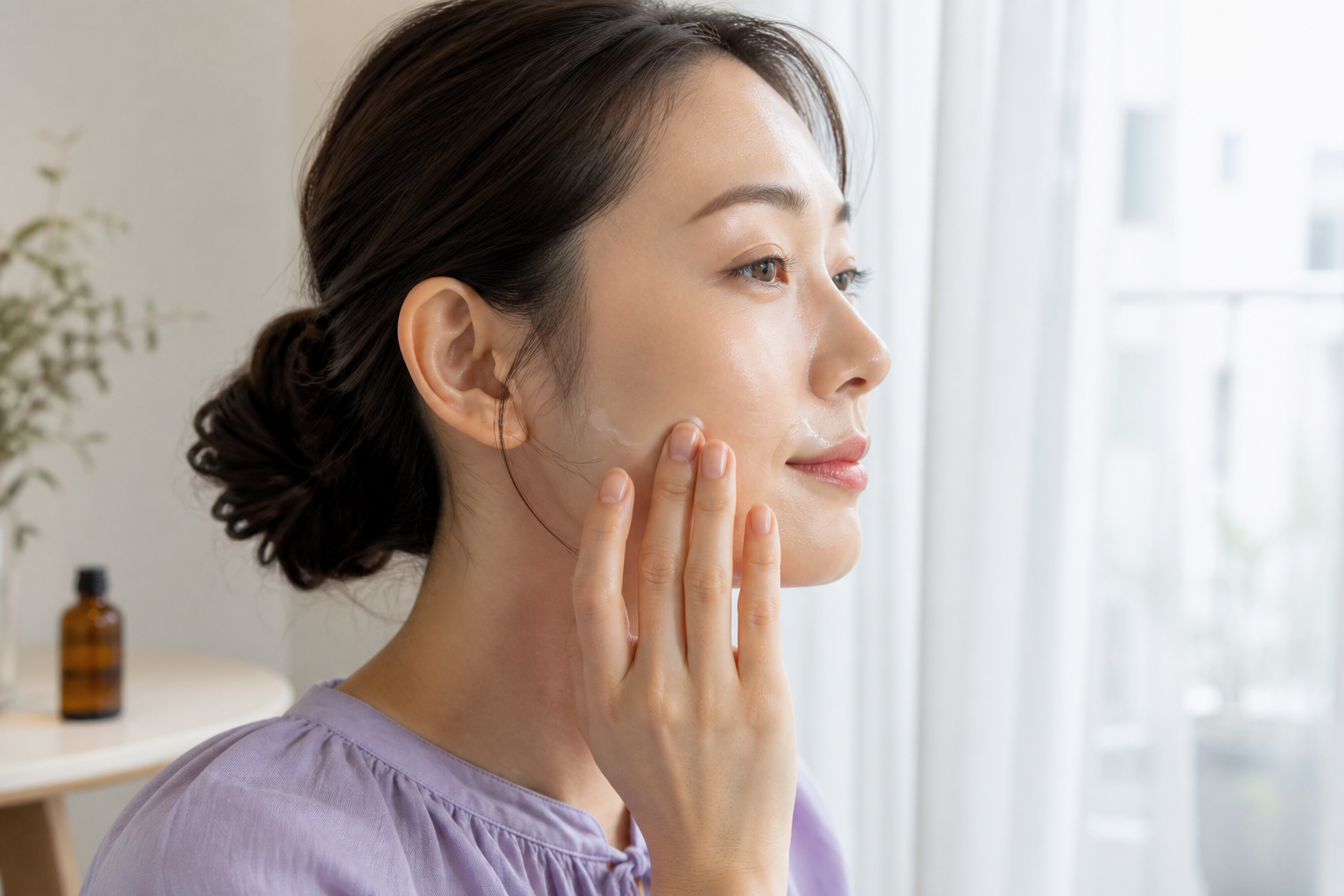 頬と口元だけへ少量の美容オイルをなじませる女性の横顔