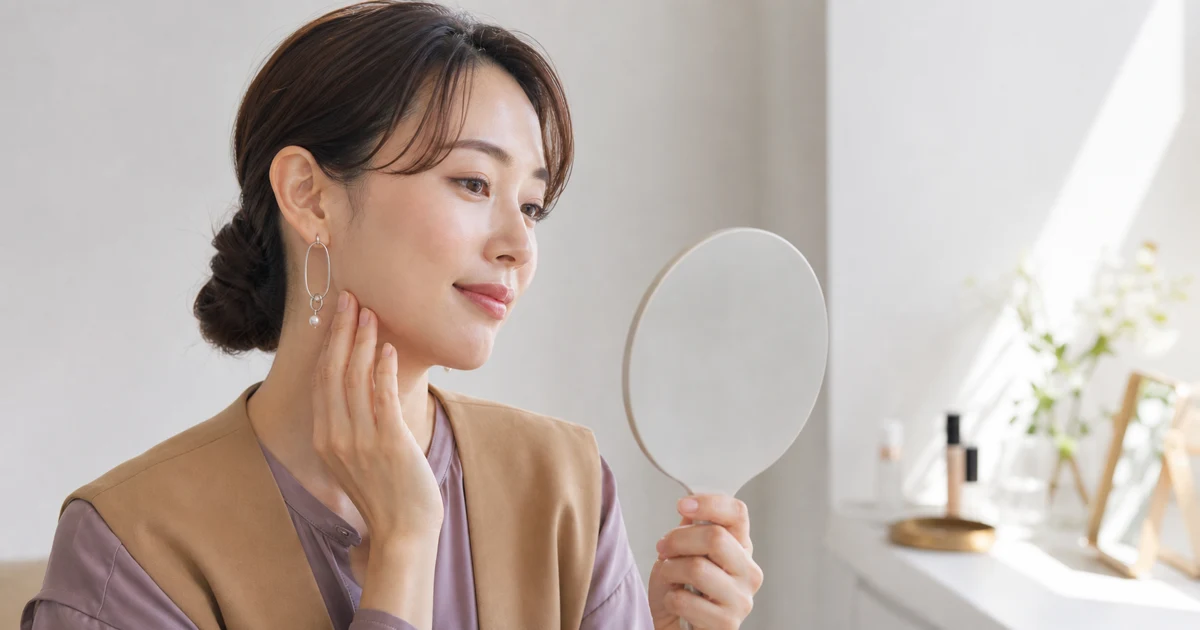 自然光のドレッサーで顔と首のファンデーション色を確認する30代女性