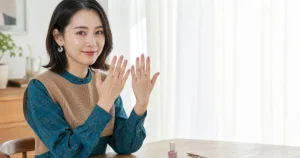 利き手と反対の手でも整えたシアーモーヴのセルフネイルを見せる20代後半の女性
