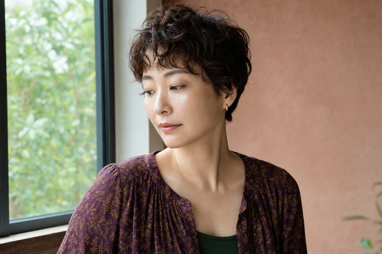 ゆるいカールヘアと透けるツヤ肌、やわらかな眉とコーラルの唇に仕上げた成人