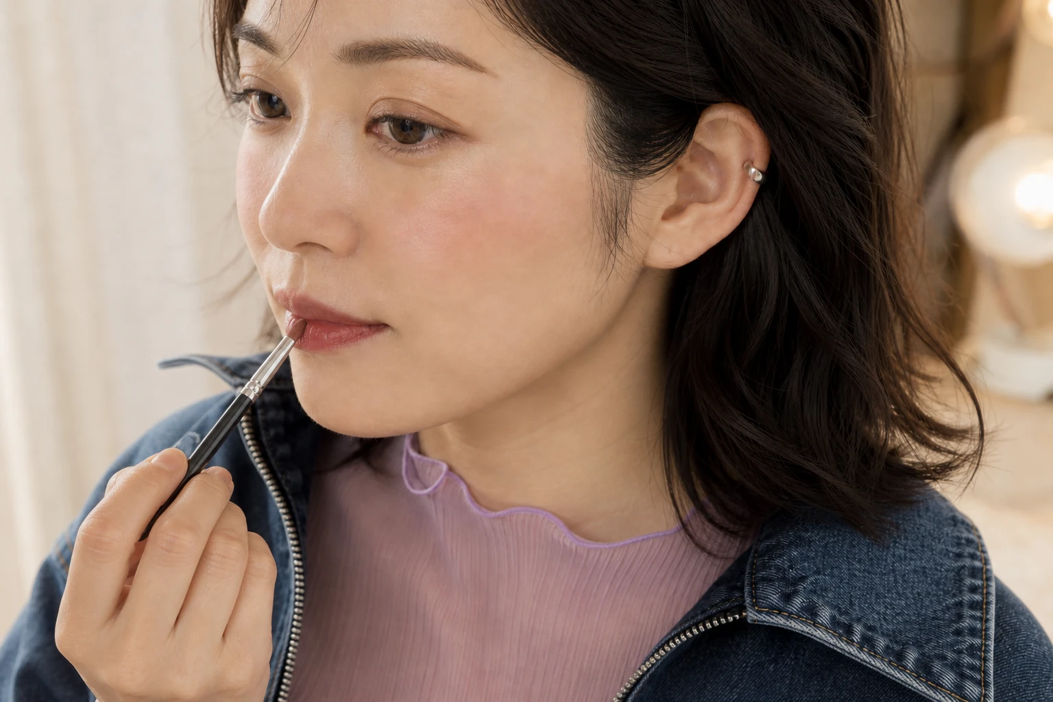 清潔なリップブラシでローズコーラルのマルチカラーを自然な唇の輪郭内へ薄く塗る30代の成人女性
