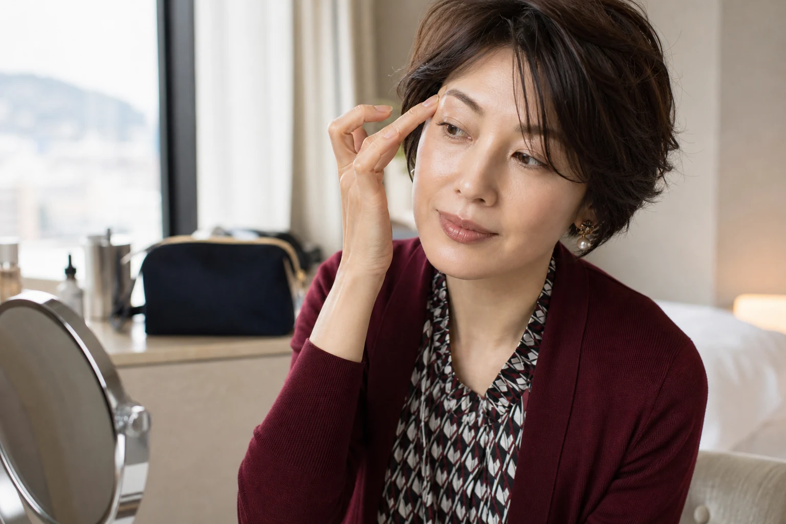 補整した眉尻周辺へ肌色コンシーラーを指先で軽くなじませる40代女性